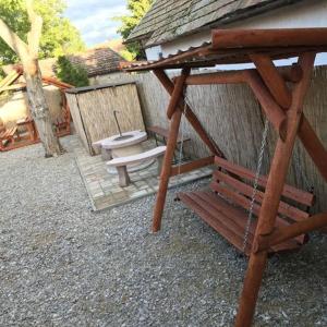 a picnic table and a bench next to a building at Flóra vendégház Tiszafüred in Tiszafüred