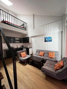 a living room with two couches and a staircase at Rezi's Apartment Vista Gudauri in Gudauri