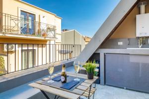 a table with two glasses of wine on a balcony at Etna e Mare Luxury Home in Zafferana Etnea