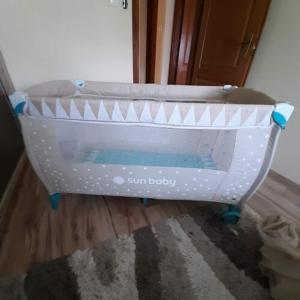 a baby crib sitting on the floor in a room at Flóra vendégház Tiszafüred in Tiszafüred