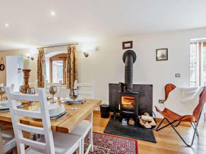 een woonkamer met een tafel en een houtkachel bij 4 Bed in Shrewsbury 50180 in Pontesbury