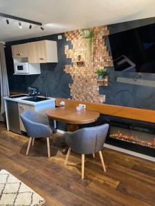 cocina con mesa de madera y 2 sillas en Le 36/Espace bien-être privatif en Bellevaux