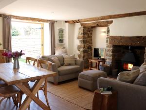 uma sala de estar com uma mesa e uma lareira de pedra em 3 bed property in Bovey Tracey 52042 em Bovey Tracey