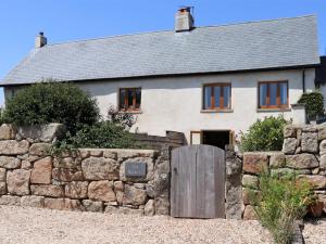 un muro di pietra di fronte a una casa bianca di 3 bed property in Bovey Tracey 52042 a Bovey Tracey