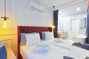 1 dormitorio con 1 cama grande y toallas. en ApartPark Lividius -Uzdrowiskowa 46 przy plaży w Świnoujściu, en Świnoujście