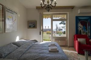 1 dormitorio con cama, silla roja y ventana en Sanremo Portosole Roomy Garden Flat, en San Remo