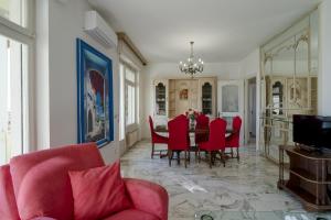 comedor con mesa y sillas rojas en Sanremo Portosole Roomy Garden Flat, en San Remo