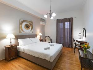 een slaapkamer met een groot wit bed en een tafel bij GORGEOUS center Apartment in Athene