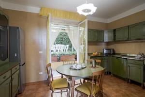 cocina con mesa, sillas y ventana en Sanremo Portosole Roomy Garden Flat, en San Remo