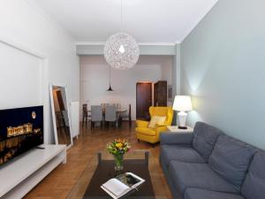 een woonkamer met een blauwe bank en een gele stoel bij GORGEOUS center Apartment in Athene