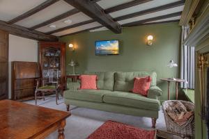 a living room with a green couch and a table at Goody Bridge Barn in Grasmere