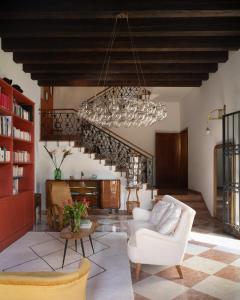 a living room with a chandelier and a white couch at Le 33 in Bassano del Grappa