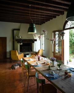 ein Esszimmer mit einem großen Holztisch und Stühlen in der Unterkunft Le 33 in Bassano del Grappa