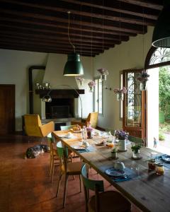 una sala da pranzo con un grande tavolo in legno e sedie di Le 33 a Bassano del Grappa