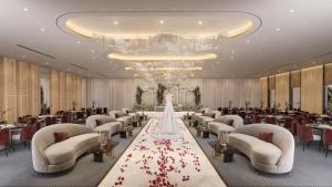 a banquet hall with tables and chairs and a chandelier at Enala Hotel- Umluj in Umm Lujj