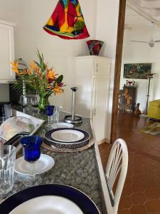 a kitchen with a table with plates and a lamp at Aura Dominica in Roseau