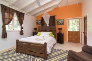 a bedroom with a bed and a couch at Aura Dominica in Roseau