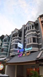 a hotel with a sign on top of a building at KPOP Hostel in Karon Beach