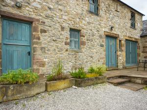 a stone building with blue doors and a patio at 3 bed in Pilsbury PK663 in Sheen