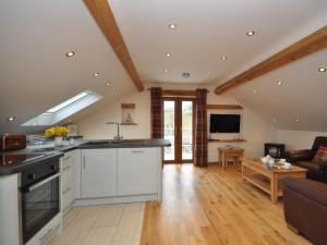 a kitchen with white cabinets and a living room at 1 Bed in Abergavenny 58309 in Abergavenny