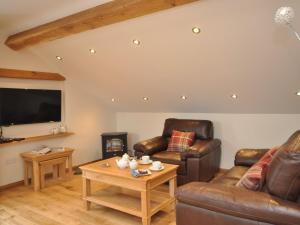 a living room with leather furniture and a flat screen tv at 1 Bed in Abergavenny 58309 in Abergavenny