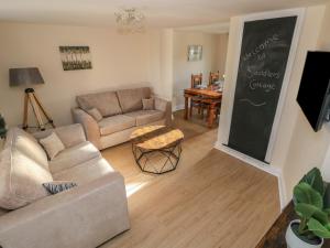 a living room with a couch and a chalkboard at Saddlers Cottage, Berllandeg Farm in Clynderwen