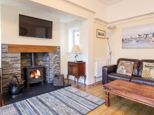 a living room with a couch and a fireplace at Meadway House in Rhôs-on-Sea