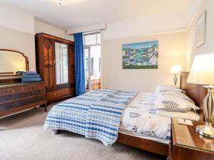 a bedroom with a bed and a dresser and a mirror at Meadway House in Rhos-on-Sea