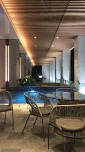 a lobby with chairs and a table and a pool at Large Comfortable Bedroom in Alam Sutera Tangerang in Kampungklapa 2 +9 photos
