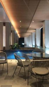 a lobby with chairs and a table and a pool at Large Comfortable Bedroom in Alam Sutera Tangerang in Kampungklapa 2