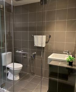 M Suite Homestay, Aeropod Sovo Kota Kinabalu في Tanjong Aru: حمام مع دش ومرحاض ومغسلة