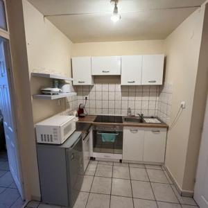 a small kitchen with a stove and a microwave at Visit apartman Tiszafüred in Tiszafüred