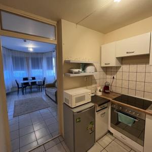 a small kitchen with a table and a dining room at Visit apartman Tiszafüred in Tiszafüred