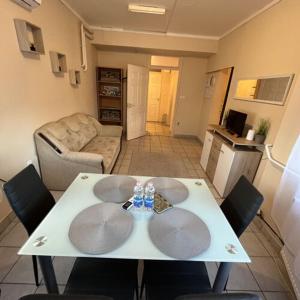 a living room with a white table and chairs at Visit apartman Tiszafüred in Tiszafüred