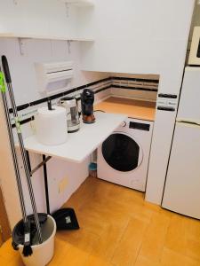 a kitchen with a microwave and a sink and a washing machine at Piso para 4 - Puerta del Sol in Madrid