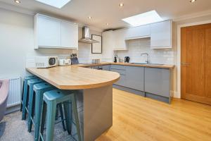 una cucina con armadi bianchi e ripiano in legno di Host & Stay - The Milton a Saltburn-by-the-Sea