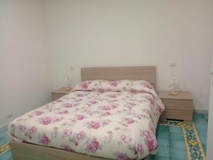 una camera da letto con un letto con fiori rosa di Let It B&B Apartment a Salerno