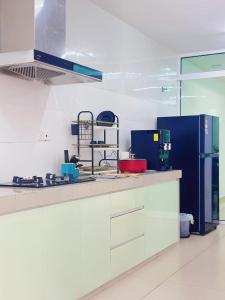 a kitchen with a counter and a blue refrigerator at Ninja's Sweet Home in Kampong Gadong Jaya