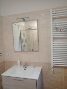 bagno con lavandino bianco e specchio di Let It B&B Apartment a Salerno