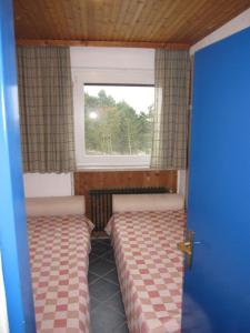 クックスハーフェンにあるCuxhaven Sahlenburgのベッド2台と窓が備わる小さな客室です。