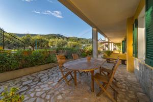 Une table et des chaises en bois sont disponibles sur la terrasse. dans l'établissement Residence gli Olmi - Goelba, à Marina di Campo
