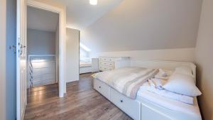 um quarto com uma cama branca e um espelho em Apartamenty Sun & Snow Jasne Wybrzeże em Jastrzebia Gora