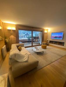 sala de estar con sofá y TV en Appartement Soleil, en Chamonix-Mont-Blanc