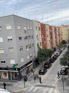 eine Stadtstraße mit Autos, die an der Seite eines Gebäudes geparkt sind in der Unterkunft Piso tranquilo y luminoso en Valencia in Valencia
