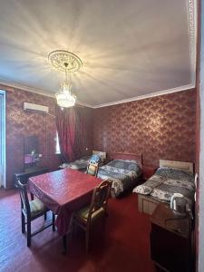 a room with two beds and a table and chairs at Sabir's Apartment Old Town in Tbilisi City