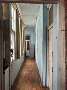 an empty hallway with blue walls and wooden floors at Sabir's Apartment Old Town in Tbilisi City