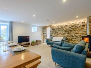 una sala de estar con sofás y una pared de piedra. en 3 Bed in Aberdovey 75025, en Llwyngwril