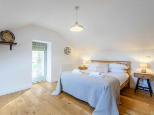 Un dormitorio blanco con una cama grande y una ventana en 3 Bed in Aberdovey 75025, en Llwyngwril