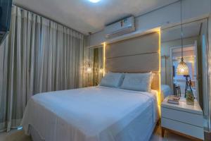 福塔萊薩的住宿－Vacation Fortaleza Apartment，卧室配有一张白色大床和镜子