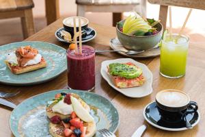 a wooden table with plates of breakfast foods and drinks at Hostal La Torre Ibiza Cap Negret in San Antonio